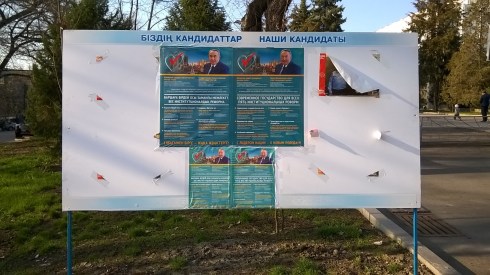 An election information board in downtown Almaty, Kazakhstan with a poster for the Leader and the communist candidate